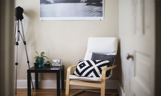 Magazine style photo of a corner of a room with a chair, side table and telescope
